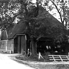 Stolpboerderij, aan de rand van het dorp gelegen, houten topgevel boven het woongedeelte. In de top een vlieringluik. Zijwand van hout (Gepotdekselde delen)
