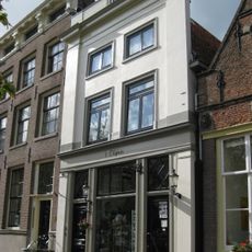 Huis met gepleisterde lijstgevel voorzien van hoekpilasters