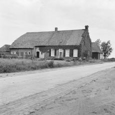 Boerderij met pannendak op het woongedeelte en rieten wolfdak op het stalgedeelte