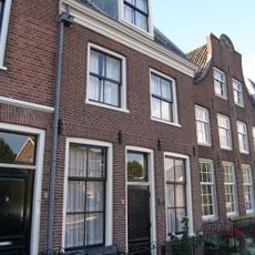 Dubbel pand met brede klokgevel, aan de top boogstuk met wapensteen