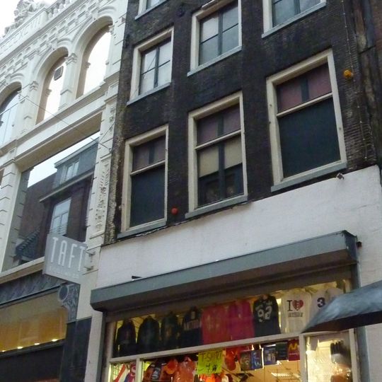 Pand met halsgevel met gesneden hijsbalk in gebeeldhouwde omlijsting