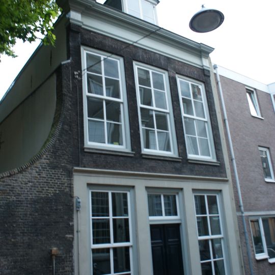 Pand met gevel met kroonlijst, die op de hoeken op bakstenen verkroppingen is omgekornist