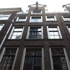 Pand met halsgevel met gedeelde vleugelstukken en palmet in de afdekking