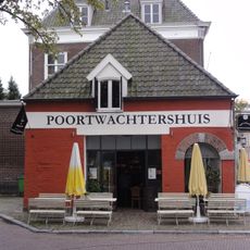 Voormalig wachthuis, thans benzinepompstation. Gebouwtje met dichtgemetselde bogen, waarvan de aanzetten en sluitstenen in natuursteen. In de vulwanden later weer vensters en een deur uitgebroken.