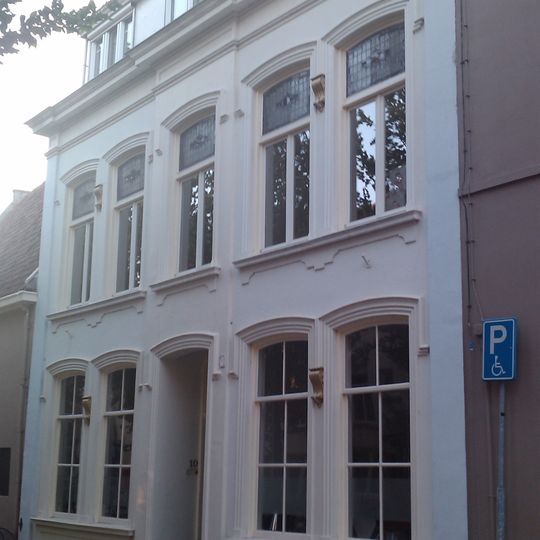 Pand met een op de omstreeks 1860-1870 gebruikelijke wijze gepleisterde lijstgevel van vijf traveeën met middenrisaliet en zijlisenen