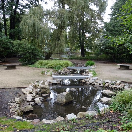 Dvojice kamenných lávek přes napájecí kanál severního jezera v Husových sadech v Sokolově