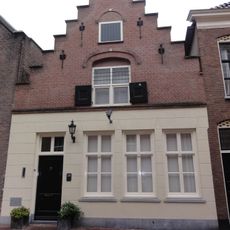 Huis met topgevel met ontlastende korfboog om bovenvenster