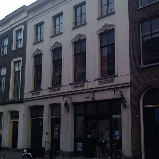 Pand met gepleisterde lijstgevel met stucversieringen