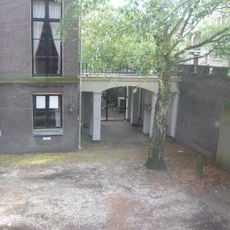 Rear entrance of Hodshon House with iron gate and gravestone (in wall)