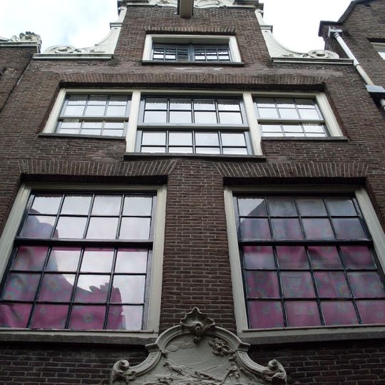 Pand met halsgevel met gedeelde vleugelstukken en palmet in de afdekking