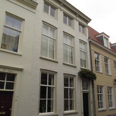 Huis met witgeschilderde lijstgevel en eenvoudige ingangsomlijsting