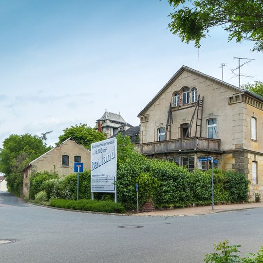 Wohnhaus in offener Bebauung, seitlicher Vorgarten mit Einfriedung und Reste des Tores sowie Wirtschaftsgebäude im Hof Badstraße 21