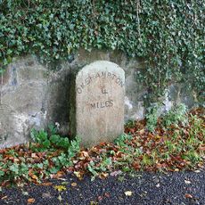 Milestone, by drive of Trafalgar House, S end of Sticklepath