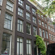 Pand met gevel onder rechte klossenlijst met consoles waarboven een schilddakje met dakkapel