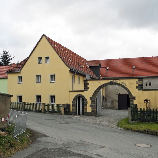 Wohnstallhaus und Scheune eines Bauernhofes, dazu Hofmauer mit Torbogen und Pforte Gorknitzer Straße 13