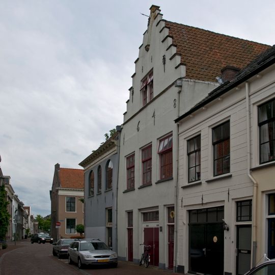 Huis met gepleisterde en door pilaster op kraagsteensierankers bekroonde trapgevel