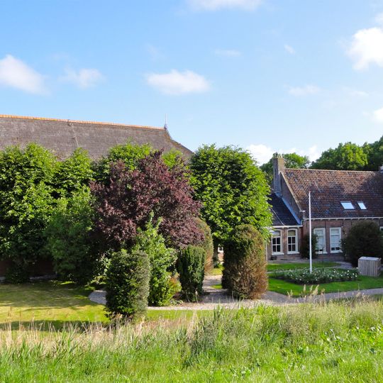 Kop-hals-rompboerderij met in het midden onderkelderd voorhuis met gevelsteen en roedenverdeling in de vensters