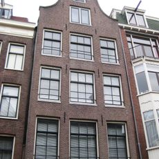 Pand met gevel bekroond door een klokvormige top onder rollagen