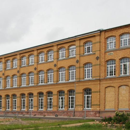 Drei Produktionsgebäude, Turbinenhaus und Schaltanlagenhaus einer Fabrikanlage sowie Schausammlung historischer Laborgeräte und Siebwalzen, weiterhin Kollergang