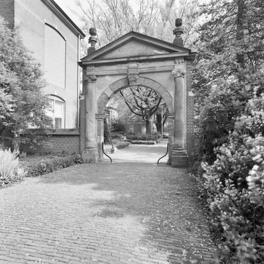 Toegangspoort met jonische halve zuilen die een hoofdgestel met fronton dragen