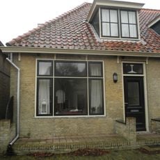 Eenvoudige woning onder hoog zadeldak