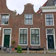 Pand halsgevel met aanzetkrullen en gezwenkte bekroningen