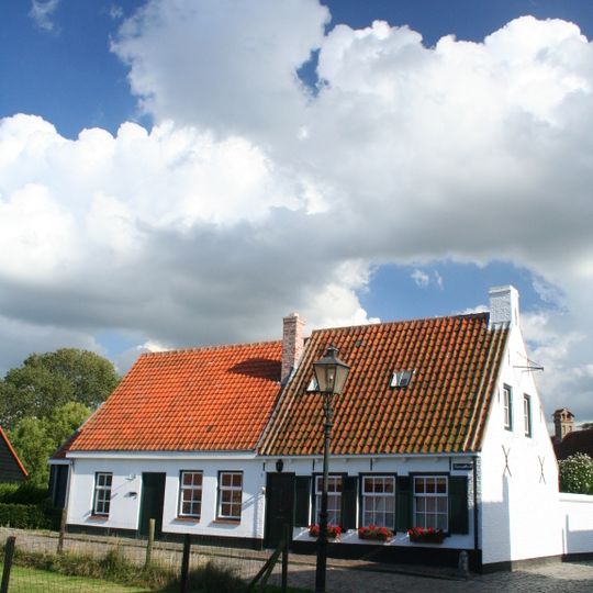 Verdiepingloos pand onder fors zadeldak, gedekt met oud-hollandse pannen
