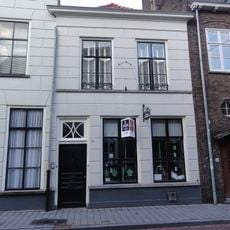 Huis met 19e-eeuwse, eenvoudige gewitte gevel, waarachter, blijkens het metselwerk, nog delen van het daar in 1591 gevestigde karthuizerklooster schuilgaan