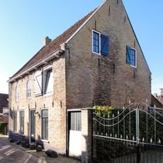 Pand met verdieping onder zadeldak tussen puntgevels met topschoorstenen