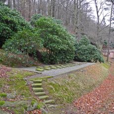Sachgesamtheit '''Alter Friedhof Bad Gottleuba''' mit Einzeldenkmalen: Gedenkstein zur Hochwasserkatastrophe des Jahres 1927, Gräberreihe für die Opfer beider Weltkriege und Einfriedungsmauer (ID-Nr. 09304377) sowie Friedhof in Hanglage mit Gehölz
