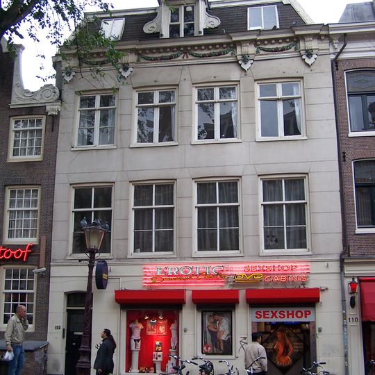 Huis met gepleisterde gevel onder versierde rechte lijst