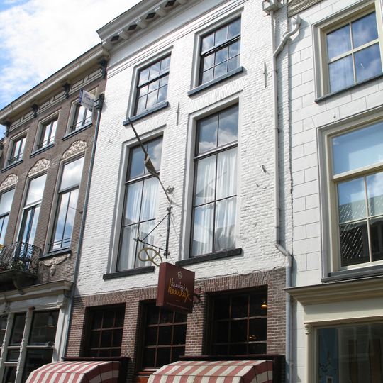 Huis met witgeverfde lijstgevel en jongere winkelpui