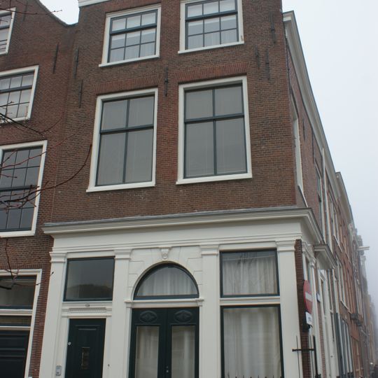 Pand met bakstenen gevel met rechte kroonlijst. Onderpui met houten pilasterstelling, zijgevel zijde Herengracht met deur en deuromlijsting. Onderpui 19e eeuw. Gerestaureerd 1940