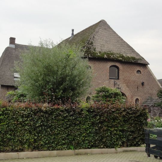 Boerderij. Woonhuis en stal vormen een T-vormige plattegrond.