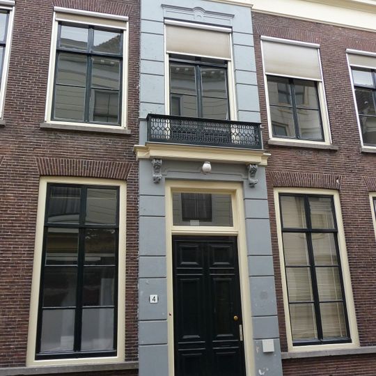 Pand met brede gevel met rechte kroonlijst vooruitspringende middenpartij, zeven ramen breed