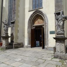 Socha svatého Vojtěcha vpravo u portálu kostela svatého Jiljí v Třeboni