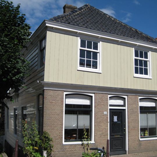 Houten dijkhuis met puntgevel aan de achterzijde, bakstenen voorpui