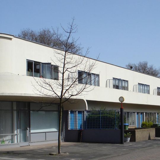 Reeks arbeiderswoningen met winkels, werk/bergplaatsen en poortgebouw