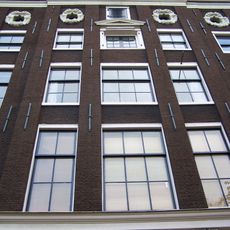 Huis uit 1642/43 verenigd achter een gezamenlijke lisenengevel met de nrs 151 en 155