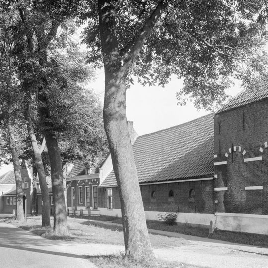 Langgerekt pand van baksteen. Vermoedelijk deel uitmakend van de oorspronkelijke dienstgebouwen van het kasteel. Vensterbogen met natuursteenblokken en maskersluitstenen