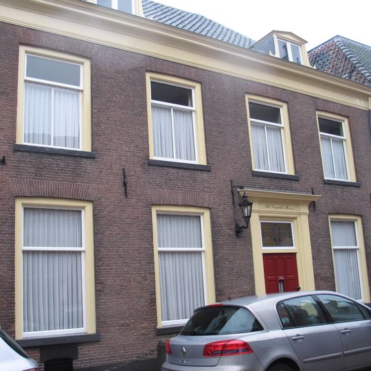 Pand waarvan de deur omlijst is door gecanneleerde pilasters