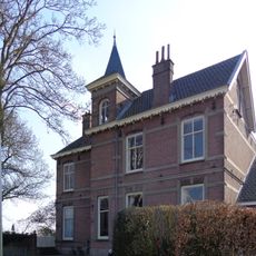 Villa met hekwerk gebouwd in een mengvorm van neorenaissance en chaletstijl