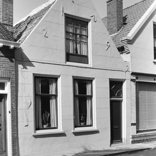 Huis met gepleisterd tuitgeveltje aan de straat, schuifvensters voordeur met bovenlicht