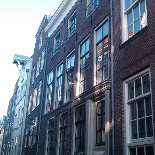 Onderkelderd huis met lijstgevel. Dakkapel met hijsbalk. Strekken boven de vensters. Gepleisterde moderne pui