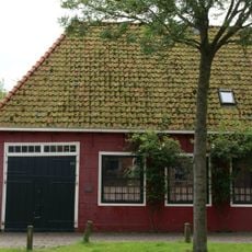 Woonhuis en werkplaats onder een dak. Gevel van woning vernieuwd. Woonhuis zou de woning van de molenmaker van de "Vijf Noorderkoggen" zijn