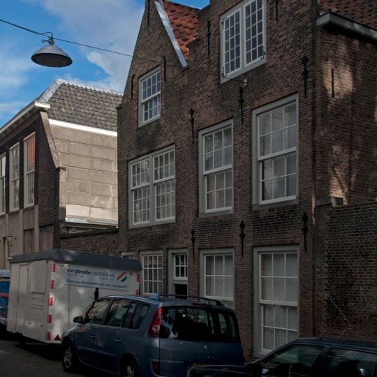 Pand met puntgeveltje met vlechtingen. Met pand rechts daarvan.