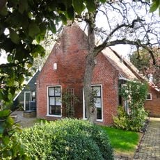 Boerderij met woonhuis tegen topgevel met zesruitsvensters