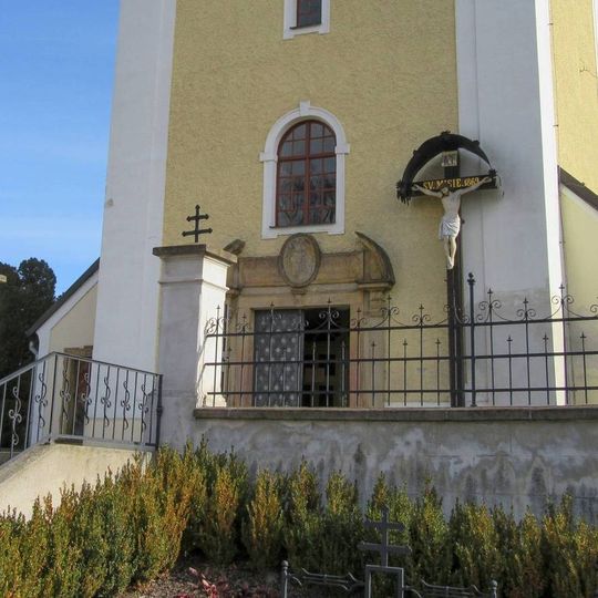 Dřevěný kříž v Senici na Hané u zdi kostela