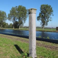 Hardstenen grenspaal voor de markering van de gemeentegrens, voorzien met het wapen van Delft