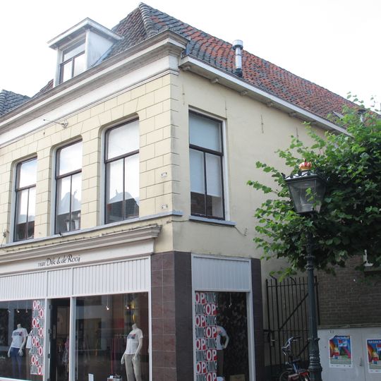 Pand met gepleisterde lijstgevel en eenvoudige winkelpui